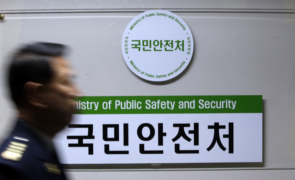 A government official walks by a signboard of newly created Ministry of Public Safety and Security at government complex in Seoul, South Korea, Wednesday, Nov. 19, 2014. South Korea's President Park Geun-hye on Tuesday nominated a retired navy general as head of the new broader safety agency to be created in the aftermath of April's ferry sinking that killed more than 300 people. (AP Photo/Lee Jin-man)
