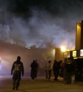 Smoke fills the streets as some buildings are on fire after the announcement of the grand jury decision Monday, Nov. 24, 2014, in Ferguson, Mo. A grand jury has decided not to indict Ferguson police officer Darren Wilson in the death of Michael Brown, the unarmed, black 18-year-old whose fatal shooting sparked sometimes violent protests. (AP Photo/Jeff Roberson)