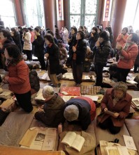 Parents pray to wish for their children' success in the Scholastic Aptitude Test at the Jogye Temple in Seoul, South Korea, Thursday, Nov. 13, 2104. About 640,000 high school students and graduates in South Korea are scheduled to take the examination Thursday that will virtually determine their admission to college. (AP Photo/Ahn Young-joon)