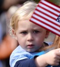 Parker Southerland, 1, waves a flag toward retired service dogs gathered at Pearson Park in Kinston, N.C., following a veteran's parade on Saturday, Nov. 8, 2014.(AP Photo/Daily Free Press, Zach Frailey)