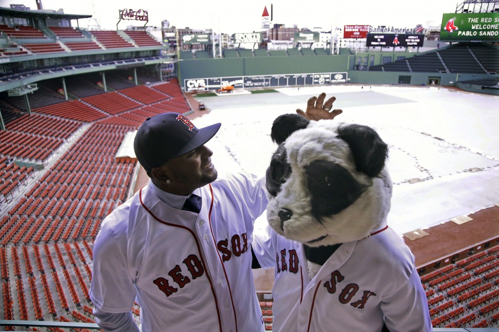 Newly acquired Boston Red Sox free agent third baseman Pablo Sandoval, nicknamed Kung Fu Panda, converses with a person dressed as a panda bear wearing a Red Sox jersey, overlooking a tarp covered Fenway Park field Tuesday, Nov. 25, 2014 in Boston. (AP Photo/Stephan Savoia)