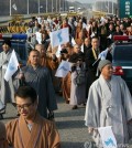 This file photo shows Buddhist priests attending the 17th annual conference of Buddhists of South Korea, China and Japan march for peace on a road near South Korea's border with North Korea, waving a flag symbolizing a reunified Korea. (Yonhap)