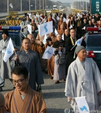 This file photo shows Buddhist priests attending the 17th annual conference of Buddhists of South Korea, China and Japan march for peace on a road near South Korea's border with North Korea, waving a flag symbolizing a reunified Korea. (Yonhap)