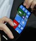 Jan. 9, 2013: Eric Rudder, chief technical strategy officer of Microsoft, holds a prototype Windows smartphone with a flexible OLED display during Samsung's keynote address at the International Consumer Electronics Show in Las Vegas. (AP Photo/Jae C. Hong)