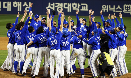 The Samsung Lions' players cheer after winning the 2014 Korea Baseball Organization (KBO) Series at Jamsil Stadium in southern Seoul, Tuesday. The Lions routed the Nexen Heroes 11-1 in game 6 of the series to become the champions for the fourth straight year. (Yonhap)