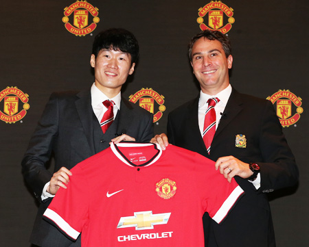 Manchester United Ambassador Park Ji-sung, left, and Jamie Reigle, Manchester United's managing director for the Asia Pacific, pose with a uniform at a media conference that took place at the Grand Hyatt Hotel, Seoul, Thursday. (Yonhap)