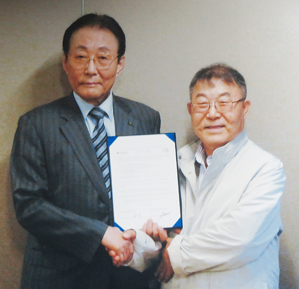 OKGM chief Kim Ho-jin, right, poses with former prime minister of South Korea Goh Kun. (Korea Times file)
