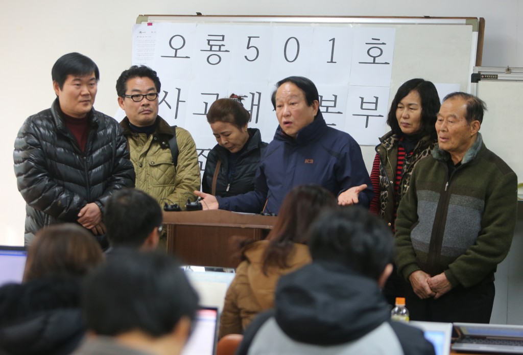 Family members of the sunken ship's crew are pleading their case to reporters. (Yonhap)