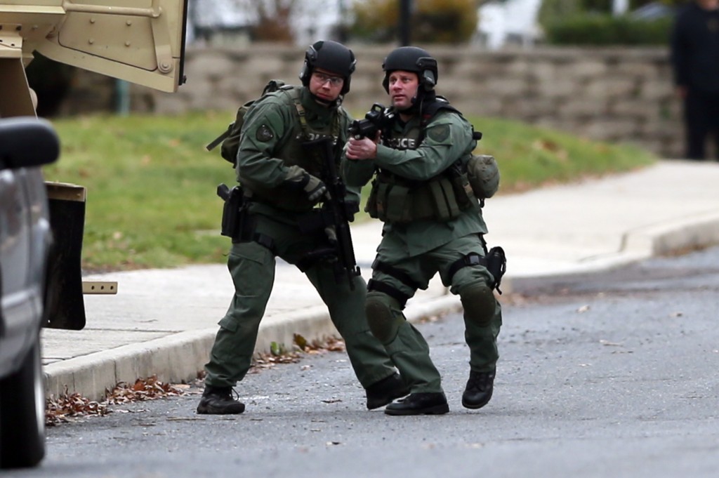 Police move near the scene of a shooting Monday, Dec. 15, 2014, in Souderton, Pa. Police are surrounding a home in Souderton, outside Philadelphia, where a suspect is believed to have barricaded himself after shootings at multiple homes. Police tell WPVI-TV the man is suspected of killing a five people Monday morning at three different homes northwest of Philadelphia.  (AP Photo/Matt Rourke)