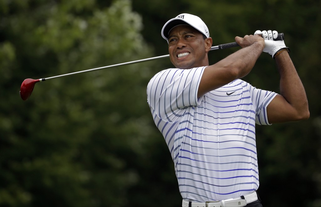 In his last tournament on Aug. 8, 2014, Tiger Woods winces after tee shot on the sixth hole during the second round of the PGA Championship golf tournament at Valhalla Golf Club in Louisville, Ky. The last time Tiger Woods was seen at a golf tournament was at the PGA Championship when he missed the cut. He returns this week at the Hero World Challenge in Windermere, Fla.  (AP Photo/Jeff Roberson, File)