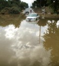 A car sits partially submerged in flood waters on Hemet Street in Hemet, Calif., Thursday morning, Dec. 4, 2014, after overnight rains doused the area.  A second day of much-needed rain is falling across drought-stricken California. (AP Photo/The Press-Enterprise, Craig Shultz )