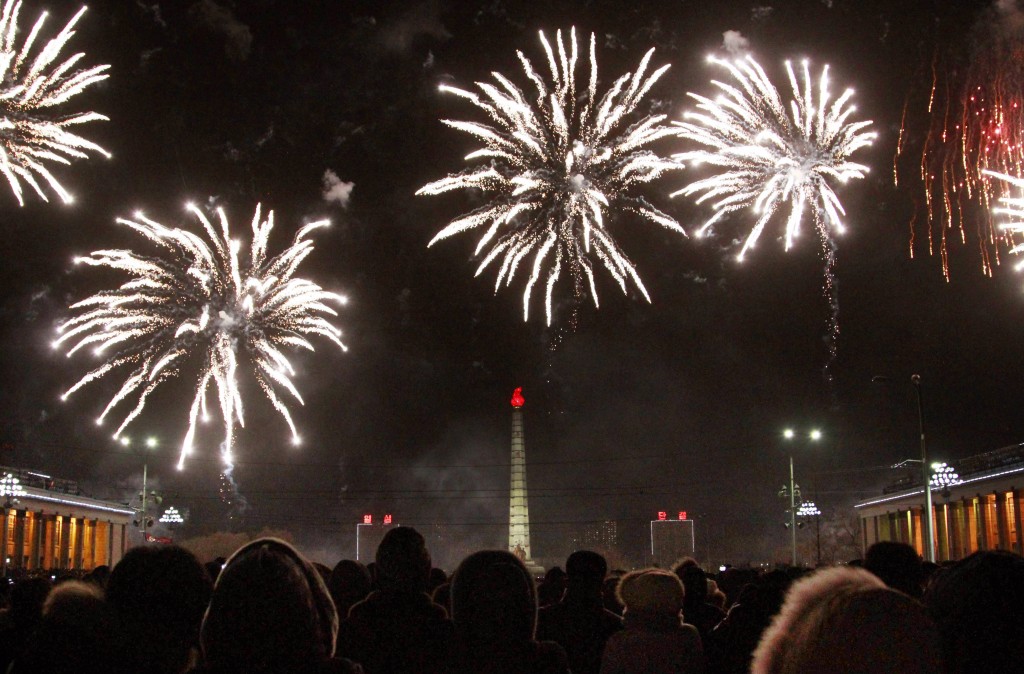 North Koreans watch as fireworks explode over the Tower of the Juche Idea to usher in the new year, Thursday, Jan. 1, 2015 in Pyongyang, North Korea. (AP Photo/Jon Chol Jin)