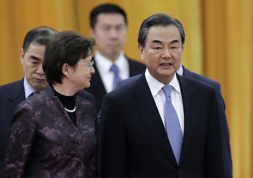 Chinese Foreign Minister Wang Yi, right, chats with a delegate as they attend a welcome ceremony for visiting Thailand Prime Minister Prayuth Chan-ocha at the Great Hall of the People in Beijing, China Monday, Dec. 22, 2014. China told the U.S. that it is against cyberattacks and opposes any nation or individual launching such attacks from a third country, but did not directly condemn the Sony hackings that Washington has blamed on North Korea, China's foreign ministry said Monday. (AP Photo/Andy Wong)