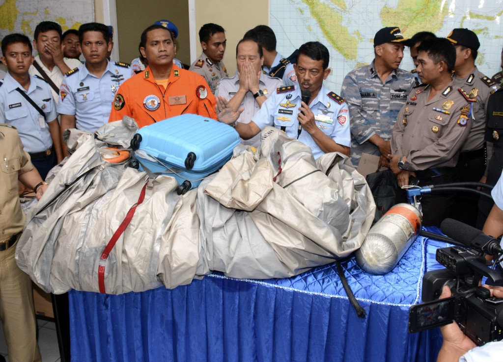 Commander of Indonesian Air Force 1st Operational Command Rear Marshall Dwi Putranto, center, shows the airplane parts and a suitcase found floating on the water near the site where AirAsia flight QZ 8501 disappeared, during a press conference at the airbase in Pangkalan Bun, Central Borneo, Indonesia, Tuesday, Dec. 30, 2014. Bodies and debris seen floating in Indonesian waters Tuesday, painfully ending the mystery of AirAsia Flight QZ8501, which crashed into the Java Sea and was lost to searchers for more than two days. (AP Photo/Dewi Nurcahyani)