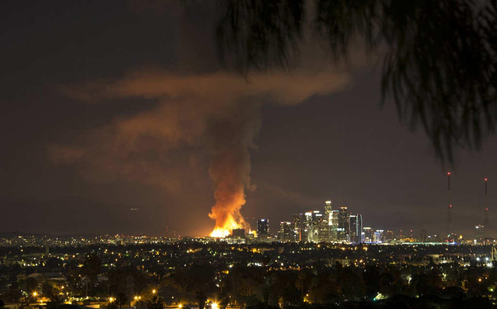 A massive fire engulfed an apartment building construction site near downtown Los Angeles on Monday, Dec. 8, 2014. Crews battled two large fires in Los Angeles early Monday, including a massive one downtown that closed portions of two major freeways and blanketed the area in ash and heavy smoke. (AP Photo/Nancy Yuille)