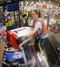 Teresa Clark fills an order at the Amazon fulfillment center in Lebanon, Tenn. on Monday, Dec. 1, 2014. Retailers rolled out discounts and free shipping deals on Cyber Monday, with millions of Americans expected to log on and shop on their work computers, laptops and tablets after the busy holiday shopping weekend. (AP Photo/Mark Humphrey)