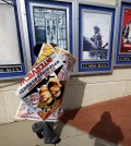 A poster for the movie "The Interview" is carried away by a worker after being pulled from a display case at a Carmike Cinemas movie theater, Wednesday, Dec. 17, 2014, in Atlanta. Georgia-based Carmike Cinemas has decided to cancel its planned showings of "The Interview" in the wake of threats against theatergoers by the Sony hackers. (AP Photo/David Goldman)