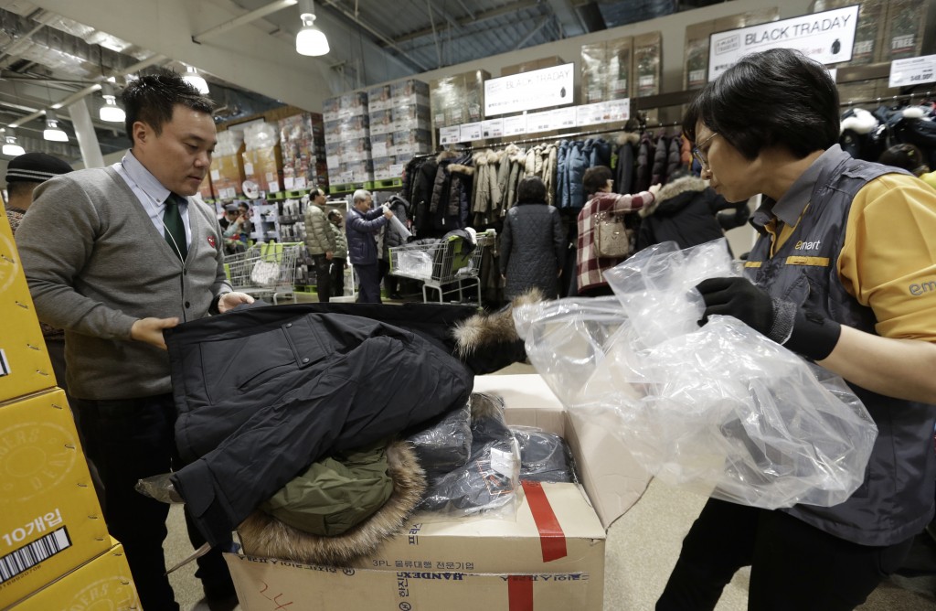 In this Nov. 28, 2014 photo,  a customer picks up to buy a down jacket directly purchased from overseas online markets at E.mart Traders in Yongin, South Korea.  The volume of goods ordered by Korean shoppers from websites overseas has surged in recent years and sales are forecast to set a record high this year above $1 billion. It remains small compared with retail sales within South Korea, which are forecast at $243 billion this year, but is expanding at a faster rate.   (AP Photo/Ahn Young-joon)