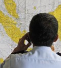 An airport official checks a map of Indonesia at the crisis center set up by local authority for the missing AirAsia flight QZ8501, at Juanda International Airport in Surabaya, East Java, Indonesia, Sunday, Dec. 28, 2014. The AirAsia plane with over 160 people on board lost contact with ground control on Sunday while flying over the Java Sea after taking off from the provincial city in Indonesia for Singapore. (AP Photo/Trisnadi)