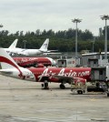 An AirAsia plane taxis, while another is parked on the tarmac at the Changi International Airport on Monday, Dec. 29, 2014 in Singapore. Search planes and ships from several countries on Monday were scouring Indonesian waters over which an AirAsia jet disappeared, more than a day into the region's latest aviation mystery. AirAsia Flight 8501 vanished Sunday in airspace thick with storm clouds on its way from Surabaya, Indonesia, to Singapore. (AP Photo/Wong Maye-E)