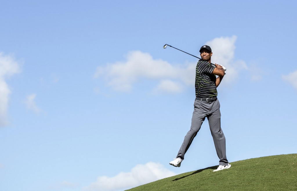 Tiger Woods chips the ball with an awkward follow through on the seventh hole during the first round of the Hero World Challenge golf tournament on Thursday, Dec. 4, 2014, in Windermere, Fla. (AP Photo/Willie J. Allen Jr.)