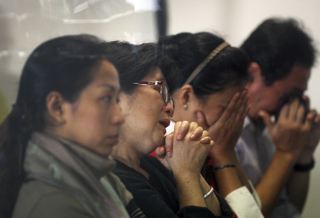 Relatives and next-of-kin of passengers on the AirAsia flight QZ8501wait for the latest news on the search of the missing jetliner at Juanda International Airport in Surabaya, East Java, Indonesia, Monday, Dec. 29, 2014. Search planes and ships from several countries on Monday were scouring Indonesian waters over which an AirAsia jet disappeared, more than a day into the region's latest aviation mystery. AirAsia Flight 8501 vanished Sunday in airspace thick with storm clouds on its way from Surabaya, Indonesia, to Singapore. (AP Photo/Trisnadi Marjan)