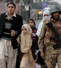 Pakistani parents escort their children outside a school attacked by the Taliban in Peshawar, Pakistan, Tuesday, Dec. 16, 2014. Taliban gunmen stormed a military-run school in the northwestern Pakistani city of Peshawar on Tuesday, killing and wounding scores, officials said, in the highest-profile militant attack to hit the troubled region in months. (AP Photo/B.K. Bangash)