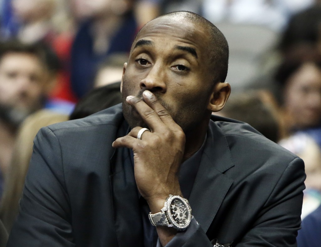 Los Angeles Lakers guard Kobe Bryant looks on from the bench in the first half of an NBA basketball game against the Dallas Mavericks, Friday, December 26, 2014 in Dallas, Texas. Bryant was sitting out his third straight game to rest his sore body but could be back in the lineup when the Lakers return home for their next outing. (AP Photo/Brandon Wade)