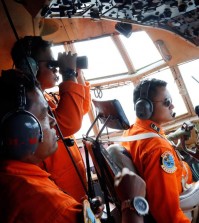 Crew of Indonesian Air Force C-130 airplane of the 31st Air Squadron scan the horizon during a search operation for the missing AirAsia flight 8501 jetliner over the waters of Karimata Strait in Indonesia, Monday, Dec. 29, 2014. Search planes and ships from several countries on Monday were scouring Indonesian waters over which the AirAsia jet disappeared, more than a day into the region's latest aviation mystery. Flight 8501 vanished Sunday in airspace thick with storm clouds on its way from Surabaya, Indonesia, to Singapore. (AP Photo/Dita Alangkara)