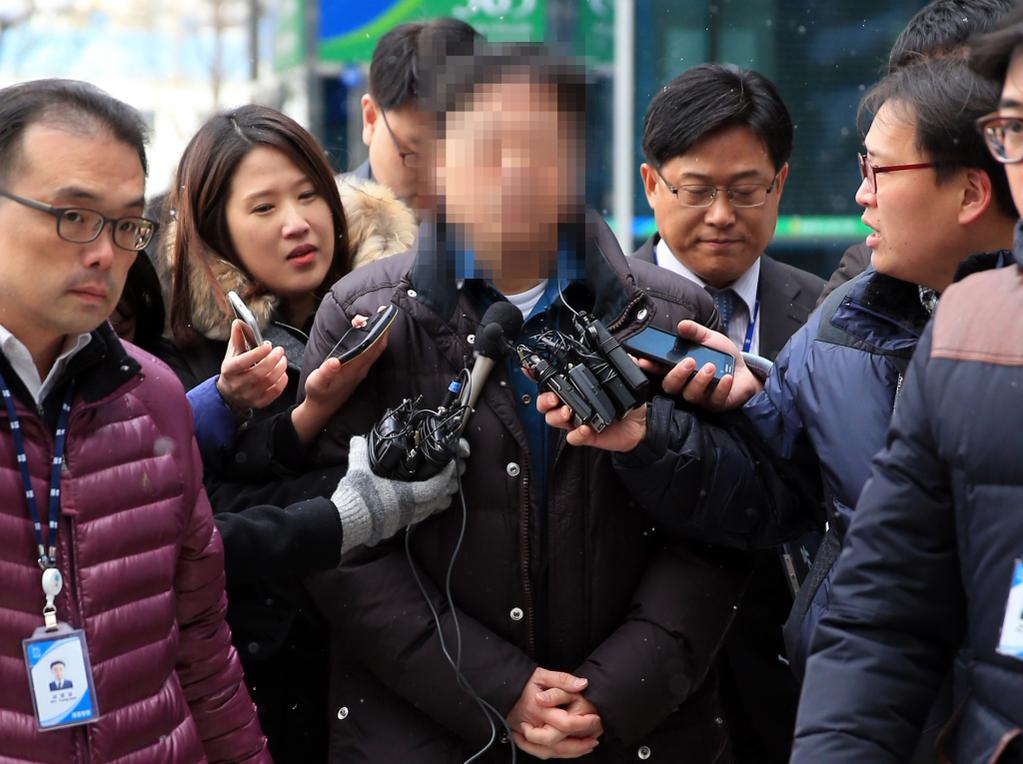 The 53-year-old professor at Seoul National University (C) is questioned by reporters before attending a prosecution probe into sexual abuse charges on Dec. 3, 2014. (Yonhap)