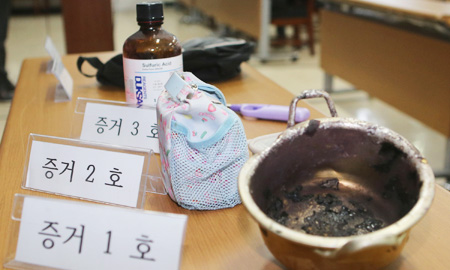 A pot and a bottle of sulfuric acid, confiscated by police after a teenager tried to attack participants of a public forum with them, are displayed with the suspect's other belongings at Iksan Police Station in South Jeolla Province, Thursday. (Yonhap)
