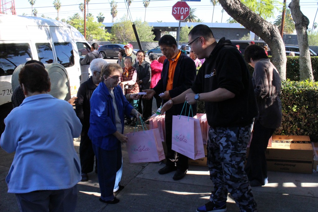 A Korean organization hands out bags filled with necessities at a senior home Tuesday in Los Angeles' Koreatown.