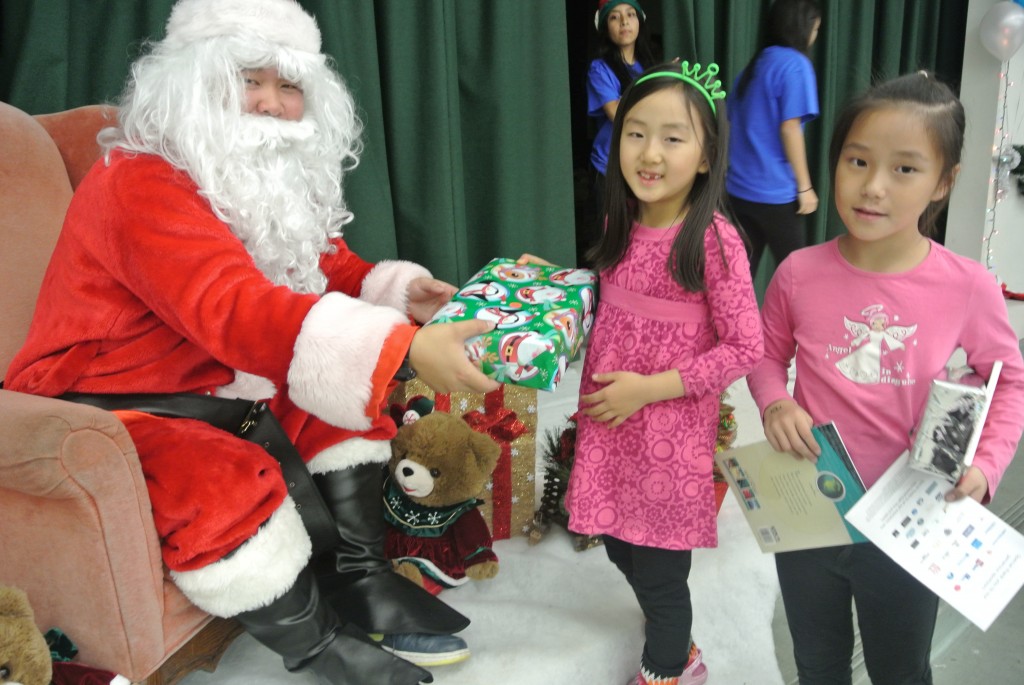 Children receive gifts from Santa at KYCC's carnival Saturday. (Park Ji-hye/The Korea Times)