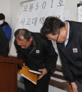 ajo Industries officials bow in apology as the company's CEO, Kim Jeong-su, left, stands nearby at the firm's offices in Busan, Tuesday. (Yonhap)