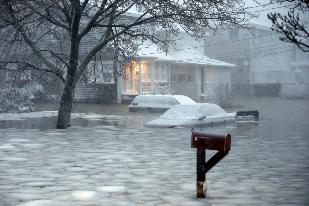Water floods a street on the coast in Scituate, Mass., Tuesday, Jan. 27, 2015. A storm packing blizzard conditions spun up the East Coast early Tuesday, pounding parts of coastal New Jersey northward through Maine with high winds and heavy snow. (AP Photo/Michael Dwyer)