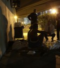 Ron Book, chairman of the Miami-Dade County Homeless Trust, center, kneeling, talks with a homeless couple sleeping under a bridge during the Point In Time Homeless Census, Thursday, Jan. 22, 2015, in Miami. The couple agreed to be sent to a shelter for the night. As part of a federal push, Miami-Dade County is aiming to end veteran homelessness by 2015, and chronic homelessness by 2016. (AP Photo/Lynne Sladky)