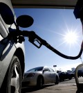 Vehicles form a line behind a motorist gassing up at a gas station where the cash price for regular unleaded is listed at $1.71, Friday, Jan. 23, 2015, in Newark, N.J. For the first time since 2009, most Americans are paying less than $2 a gallon. (AP Photo/Julio Cortez)