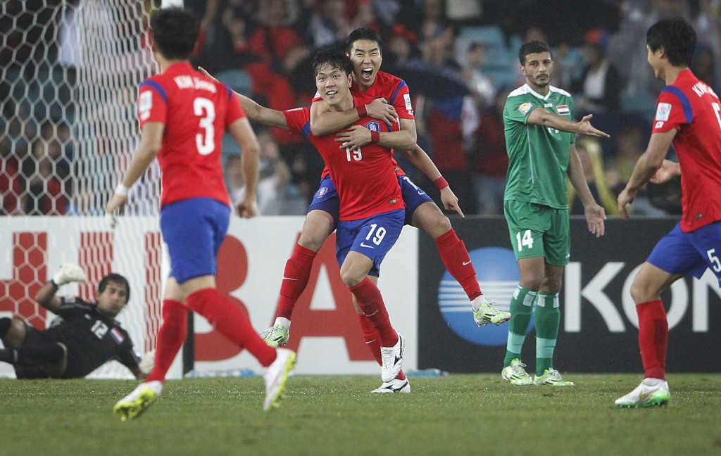 South Korea's Lee Jeonghyeop, center back, hugs his team mate Kim Young Gwon, after Kim scored his country's second goal during the AFC Asian Cup semifinal soccer match between South Korea and Iraq in Sydney, Australia, Monday, Jan. 26, 2015. (AP Photo/Quentin Jones)