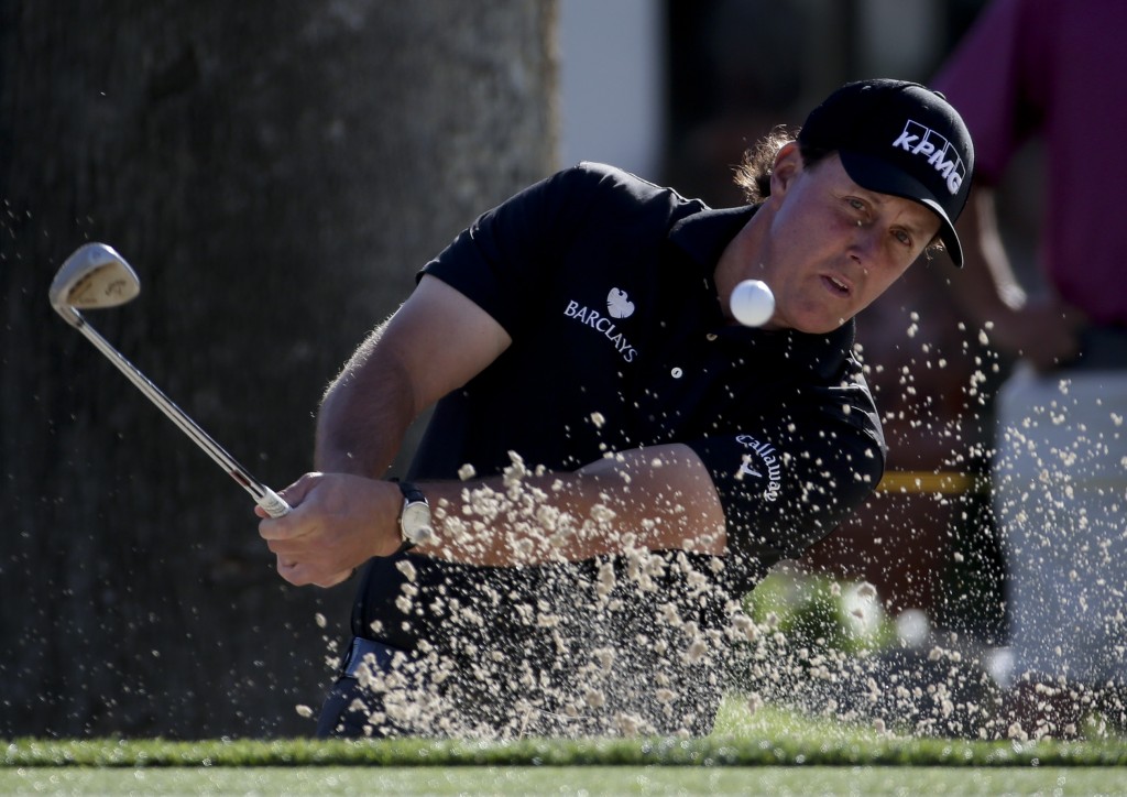 Phil Mickelson watches his bunker shot on the fourth hole during the first round of the Humana Challenge golf tournament at the La Quinta Country Club on Thursday, Jan. 22, 2015 in La Quinta, Calif. (AP Photo/Chris Carlson)