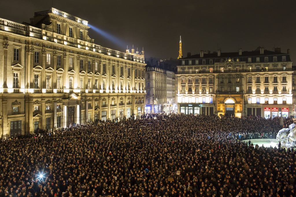 Thousands of people gather for a moment of silence to pay their respects to the victims of the deadly attack at the Paris offices of French satirical newspaper Charlie Hebdo, in Lyon, central France, Wednesday, Jan. 7, 2015. Masked gunmen stormed the Paris offices of a weekly newspaper that caricatured the Prophet Muhammad, killing at least 12 people, including the editor, before escaping in a car. It was France's deadliest postwar terrorist attack. (AP Photo/Laurent Cipriani)