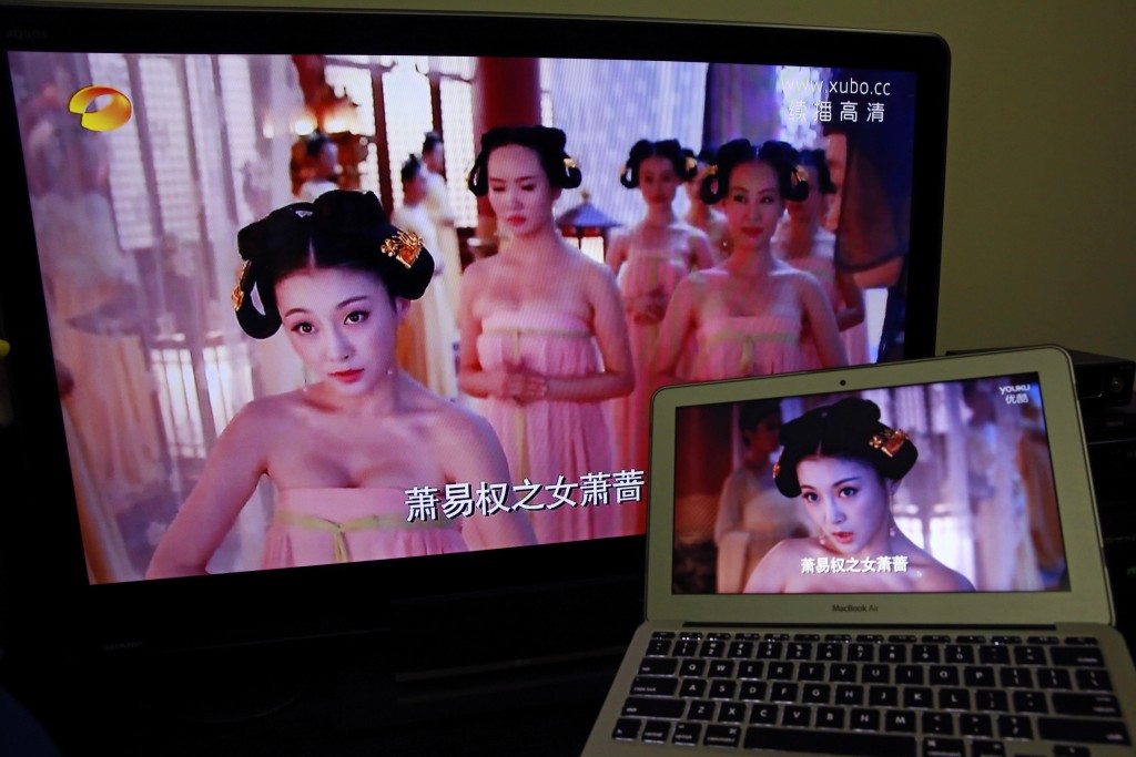 A television at left displays the original version of a popular drama next to a computer displaying the version that was re-edited in Beijing, China, Thursday, Jan. 8, 2015. The popular television drama chronicling China’s best-known empress and featuring buxom actresses went on a four-day, unexplained hiatus. When it returned on New Year’s Day, the low-cut necklines and squeezed bosoms had vanished. (AP Photo/Andy Wong)