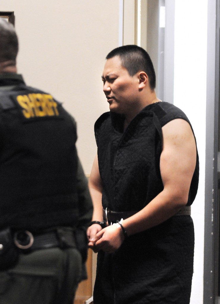 FILE - In this Jan. 12, 2015, file photo, John Lee is escorted into the Superior Courtroom in Whitman County, in Colfax, Wash., for his first appearance on a felony eluding charge. Lee is suspected of fatally shooting three people  including his mother  before leading authorities on a high-speed chase is fighting extradition back to Idaho. Lee's decision Friday, Jan. 16, to not waive the formal extradition process means Idaho Gov. C.L. "Butch" Otter will have to request extradition from Washington Gov. Jay Inslee. (AP Photo/Lewiston Tribune, Kyle Mills)