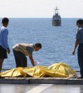 Crew members inspect bags containing bodies believed to be victims of AirAsia Flight 8501 on the deck of Indonesian Navy ship KRI Banda Aceh, on the Java Sea, Indonesia, Friday, Jan. 23, 2015. The ill-fated jetliner plunged into the java Sea while en route from Surabaya, Indonesia's second-largest city, to Singapore last month. (AP Photo/Natanael Pohan)