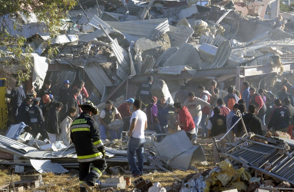 Rescue workers comb through the rubble of a children's hospital after a gas truck exploded, in Cuajimalpa on the outskirts of Mexico City, Thursday, Jan. 29, 2015. The powerful explosion shattered the hospital on the western edge of Mexico's capital, killing at least three adults and one baby and injuring dozens. (AP Photo)