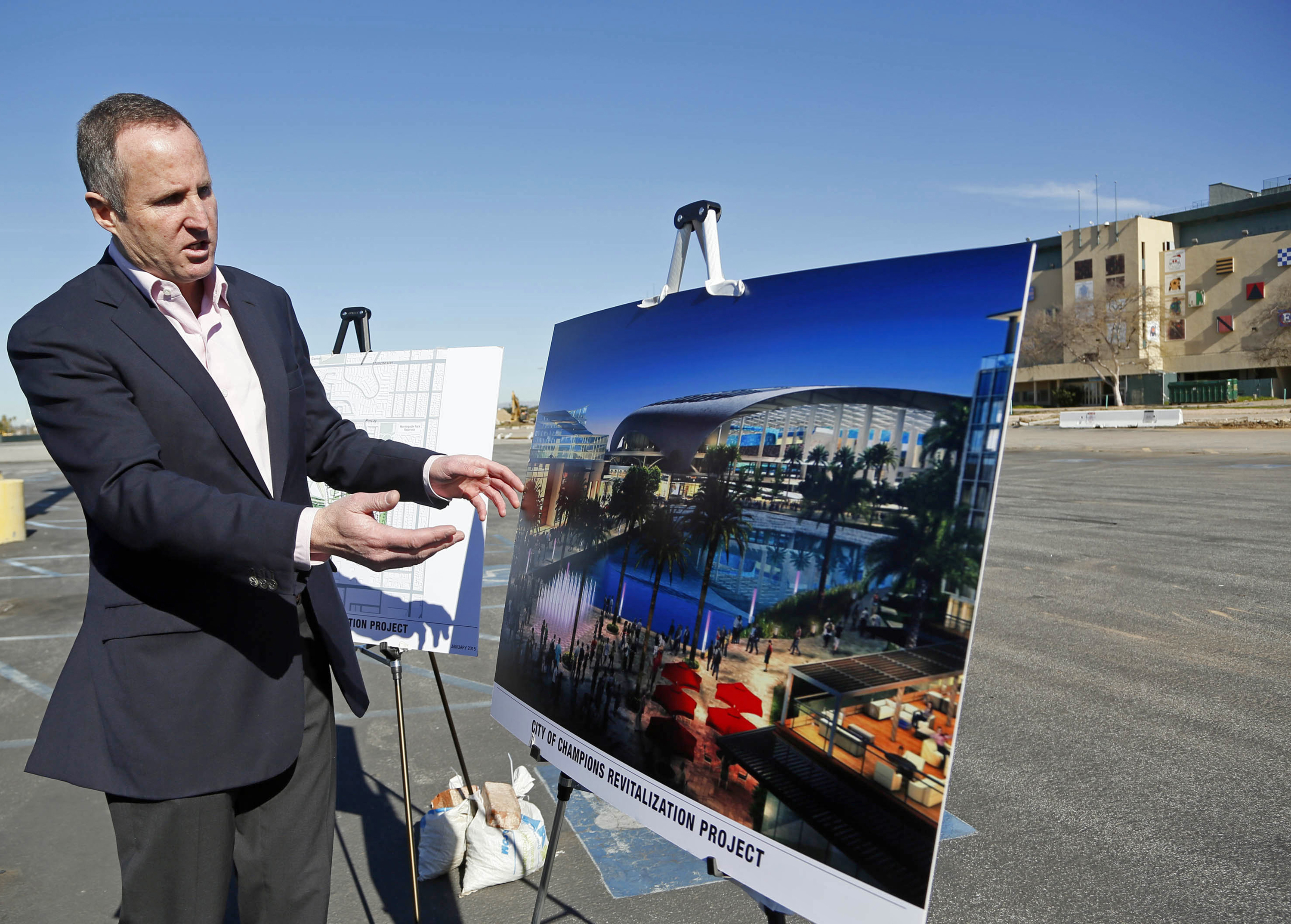Chris Meany, senior vice president of Hollywood Park Land Company unveils an architectural rendering of a proposed NFL stadium at Hollywood Park in Inglewood, Calif., Monday, Jan. 5, 2015. The owner of the St. Louis Rams plans to build an NFL stadium in Los Angeles County, boosting the chances that pro football could return to the region, according to the Los Angeles Times. Stan Kroenke has partnered with Stockbridge Capital Group, owners of the 238-acre Hollywood Park site in Inglewood, the newspaper reported Monday. (AP Photo/Nick Ut)