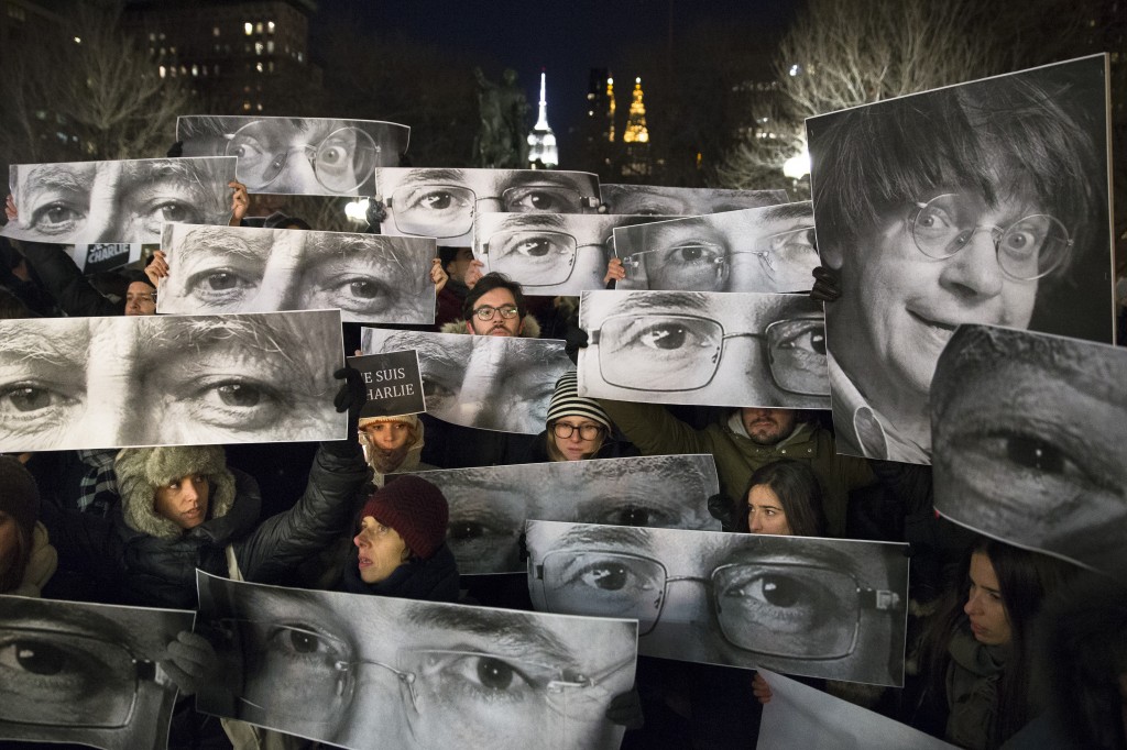 People from all over the world have shown support for the victims in France. Mourners hold signs depicting victim's eyes during a rally in support of Charlie Hebdo, a French satirical weekly newspaper that fell victim to an terrorist attack, Wednesday, Jan. 7, 2015, at Union Square in New York. French officials say 12 people were killed when masked gunmen stormed the Paris offices of the periodical that had caricatured the Prophet Muhammad. (AP Photo/John Minchillo)