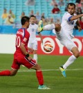 Uzbekistans Shavkatjon Mulladjanov kicks the ball as North Koreas Pak Kwang Ryong attempts to block during the first round soccer match of the AFC Asia Cup between Uzbekistan and North Korea in Sydney, Australia,  Saturday, Jan. 10, 2015. (AP Photo/Rob Griffith)