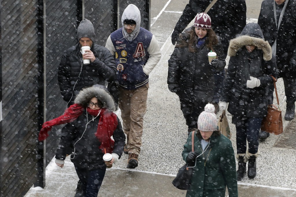 A light snow falls on pedestrians, Monday, Jan. 26, 2015 in New York. The National Weather Service says accumulations of 18 to 24 inches are possible by Tuesday afternoon. (AP Photo/Mark Lennihan)