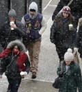 A light snow falls on pedestrians, Monday, Jan. 26, 2015 in New York. The National Weather Service says accumulations of 18 to 24 inches are possible by Tuesday afternoon. (AP Photo/Mark Lennihan)