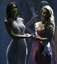 Paulina Vega of Colombia, left, and Nia Sanchez of the U.S., hold hands as the wait for the announcement of who will be selected as Miss Universe, Sunday, Jan. 25, 2015, during the Miss Universe pageant in Miami. (AP Photo/Wilfredo Lee)